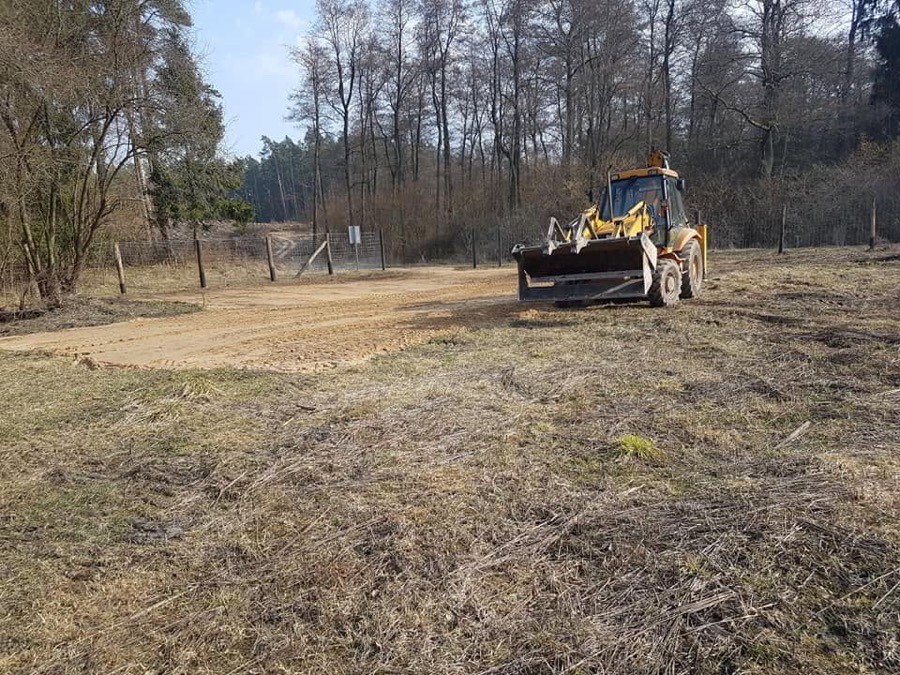 Koparko-ładowarka SEBEST podczas pracy przy oczyszczaniu terenu